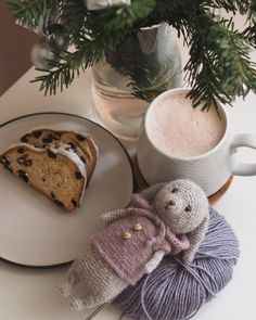 a stuffed animal sitting on top of a white plate next to a cup of coffee