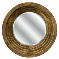 a round wooden mirror sitting on top of a table