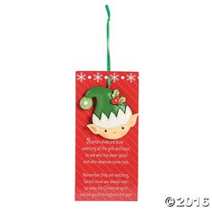 a christmas ornament with an elf's hat hanging from the side on a red background