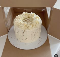 a white frosted cake in a cardboard box