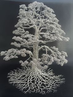 a white tree with many branches and roots on it's black surface, in front of a black background