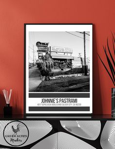 a black and white photo of a restaurant sign on a shelf next to a vase