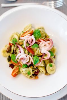 a white plate topped with pasta and vegetables