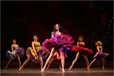 a group of women in colorful dresses on stage