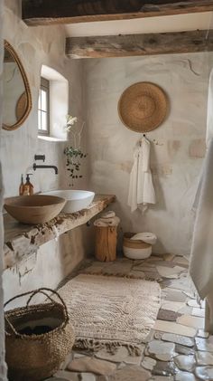 a rustic bathroom with stone floors and white walls, two sinks on either side of the bathtub