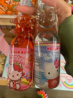 someone is holding two hello kitty sodas in their hand and one has strawberry juice on it