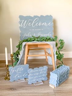 a welcome sign and other decorations on a wooden floor next to a table with candles