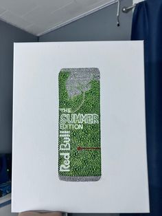 a cell phone covered in green grass on top of a white box with the words summer written on it