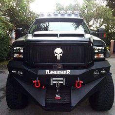 the front end of a black truck with a skull on it's bumper and lights