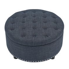 a round ottoman with studding on the top and bottom, in dark blue linen