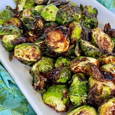 brussel sprouts on a white plate sitting on a blue tablecloth