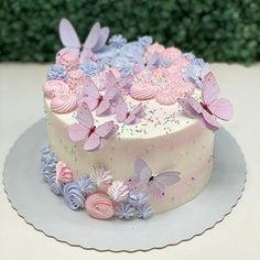 a white cake with pink and purple butterflies on it