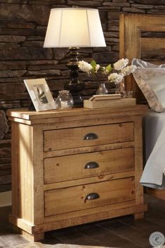 a bed with a wooden headboard and night stand next to a lamp on the nightstand