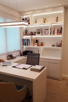 a desk with a laptop computer on top of it next to a book shelf filled with books