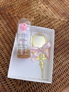 a small bottle with a pink rose on it next to a keychain