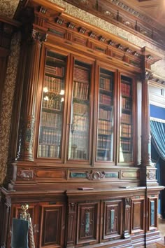 an old wooden bookcase with many books on it's shelves in a room