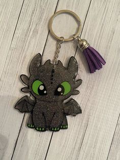 a keychain with an image of a little dragon on it's face