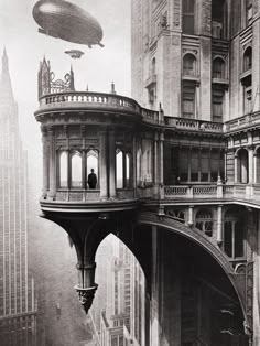 an old black and white photo of a man standing on top of a building in the middle of a city