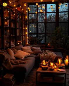 a living room filled with lots of furniture covered in blankets and lite up candles