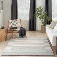 a living room with white furniture and curtains