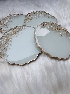 three decorative mirrors sitting on top of a white fur covered floor next to each other