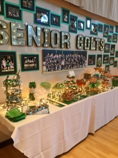 a table covered with lots of candy and candies next to pictures on the wall