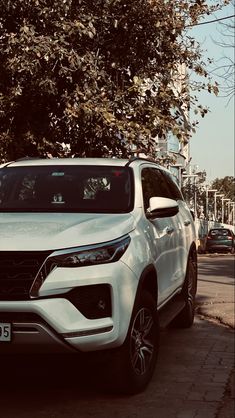 a white car is parked on the side of the road