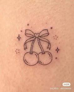 a small teddy bear with a bow tattoo on the back of someone's shoulder