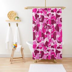 a pink camo shower curtain hanging on a wall next to a white bath tub