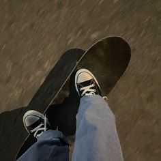 a person standing on top of a skateboard next to another person's feet