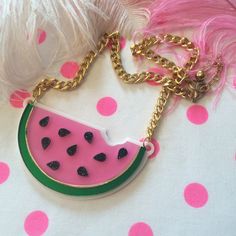 "This is a scrumptious necklace for all seasons! Bring the fun to any outfit with this big and bold watermelon necklace. This original design has been laser cut out of a mix of glitter, mirror, and opaque 1/8\" acrylic sheet and is backed with white, 1/16\" acrylic. The necklace hangs from a thick, gold chain and measures about 16\". We love these necklaces and think that they never get old. However, to prolong the life of yours, treat it with love! Be careful when storing it in a bag or pocket Cute Summer Party Necklaces, Cute Party Necklaces For Summer, Fun Resin Jewelry For Parties, Fun Resin Jewelry For Party, Fun Resin Party Jewelry, Trendy Handmade Resin Necklace, Trendy Resin Necklaces For Party, Pink Resin Party Necklaces, Fun Summer Necklaces For Gifts