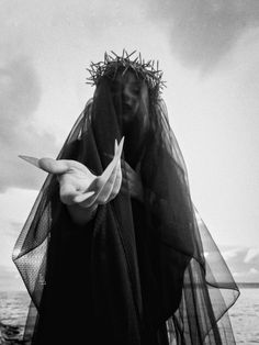 a black and white photo of a woman wearing a veil