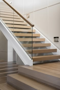 a wooden stair case with glass railing