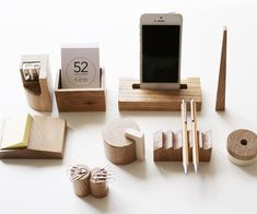 various wooden objects are arranged on a white surface with a cell phone and other items