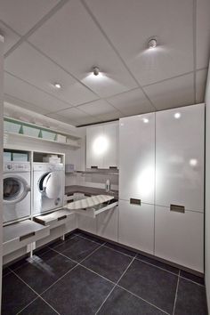 a washer and dryer in a room with tile flooring on the walls