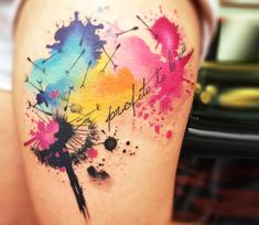 a woman's thigh with watercolor paint splatters and words on it