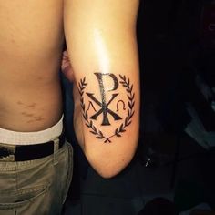 a person with a tattoo on their arm and the letter k in an ornamental wreath