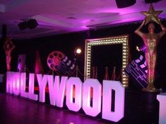 the hollywood sign is lit up with purple lights and decorations in front of a mirror