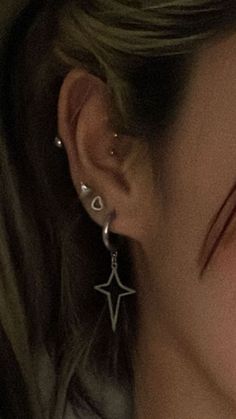 a close up of a person wearing ear rings and earrings with an upside down look on their face