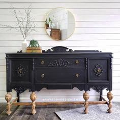 an old dresser is painted black with gold accents