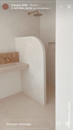 a bathroom with a sink, toilet and shower in the corner next to a white wall