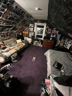 a messy bedroom with purple carpet and lots of books on the walls, furniture and other items