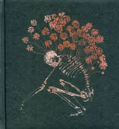 a skeleton with flowers in it's head is sitting on the ground next to a black background