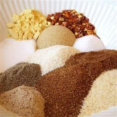 several different types of spices in a white bowl