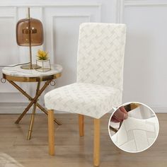 a white chair next to a table with a lamp on top of it and a gold side table