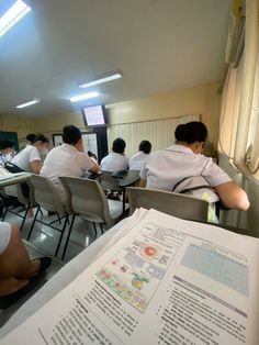 several people sitting at desks with papers in front of them