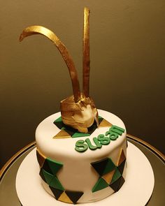 a white cake with green and gold decorations