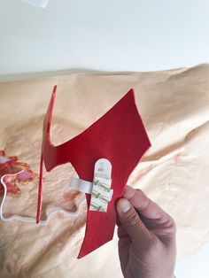 a hand holding a red piece of paper