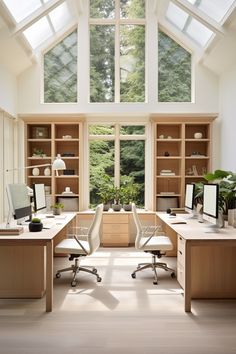 a home office with two desks and large windows