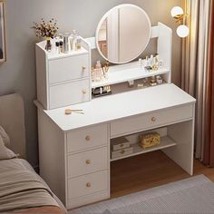 a bedroom with a bed, dresser and mirror on it's side table in front of a window